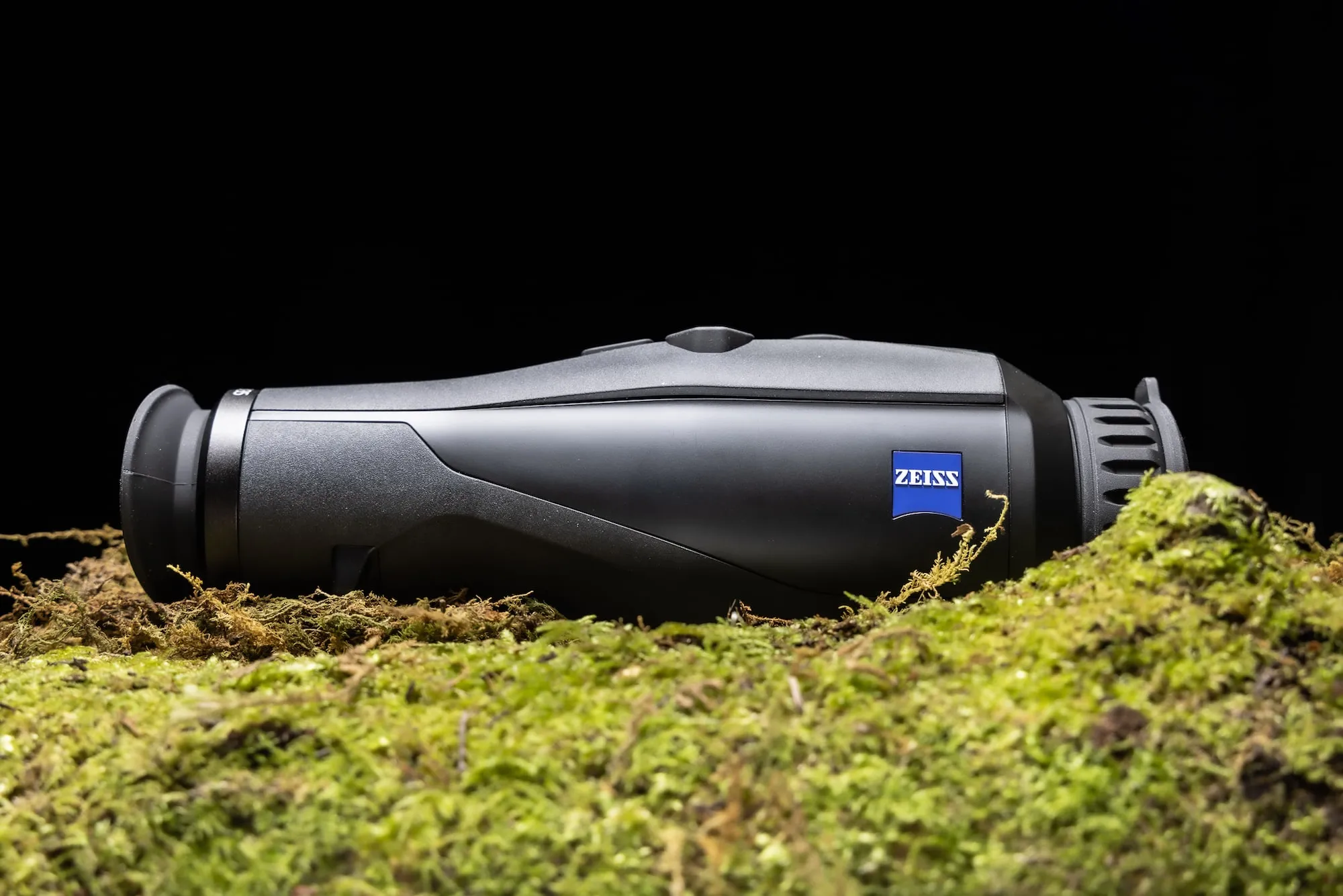 A Zeiss Thermal imager against a black background on moss
